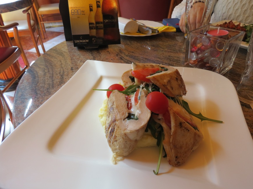Italian food in Budapest: cheese & herb-stuffed chicken topped with tomatoes.